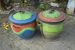 duas latas de lixo coloridas de pneus de borracha de carro usado. foto