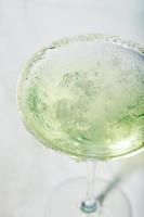 coquetel de martini com gelo e uma fatia de limão no fundo da mesa de mármore. coquetel alcoólico ou mocktail sem álcool. foto