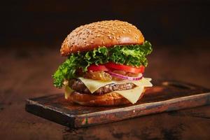 hambúrguer caseiro com marmelada de carne, queijo e cebola em uma placa de madeira. conceito de fast food, comida americana