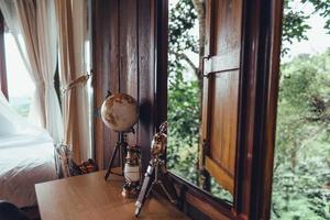 globo em uma mesa de madeira em uma casa de madeira, viajar pelo mundo foto