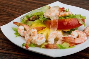 camarões com salada de aloe vera no prato e fundo de madeira foto