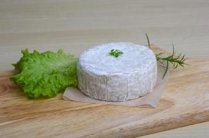 queijo camembert na tábua de madeira e fundo de madeira foto