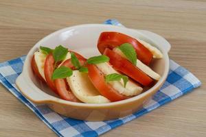 caprese em uma tigela com fundo de madeira foto