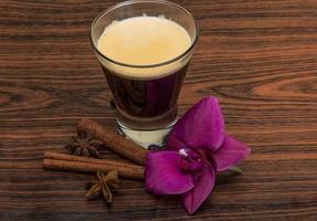 café expresso com orquídea em fundo de madeira foto