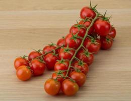 tomate cereja em fundo de madeira foto