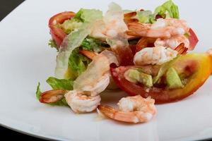 camarões com salada de aloe vera no prato e fundo de madeira foto