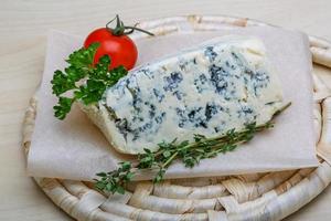 queijo azul na placa de madeira e fundo de madeira foto