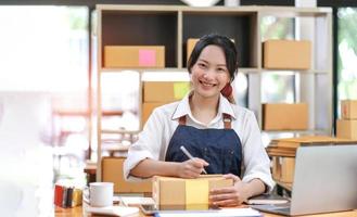 retrato de mulher jovem asiática sme trabalhando com uma caixa em casa, o proprietário de uma pequena empresa local de trabalho. foto