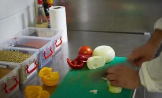 chef na cozinha do hotel fatia de legumes com faca foto