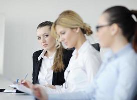 mulher de negócios em pé com sua equipe em segundo plano foto