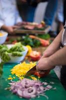 mãos de chef cortando legumes frescos e deliciosos foto