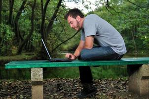 jovem empresário trabalhando no laptop ao ar livre foto
