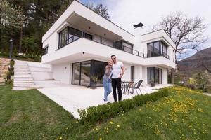 casal se abraçando em frente a nova casa de luxo foto