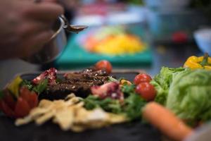 chef acabamento de mão prato de carne de bife foto