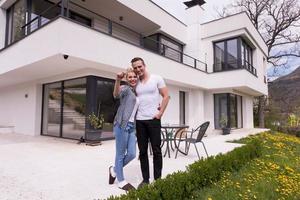 casal se abraçando em frente a nova casa de luxo foto