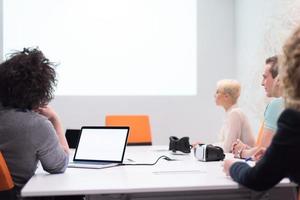 equipe de negócios de inicialização em uma reunião no prédio de escritórios à noite moderna foto