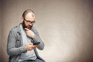 homem pensativo de estilo de vida com barba e telefone, plano de fundo, copyspace foto