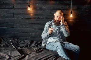 freelancer homem cansado com dor de cabeça, sobrecarga salarial foto