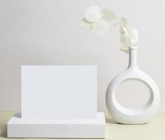 cartão de felicitações vista frontal e flor seca em vaso de cerâmica na mesa foto