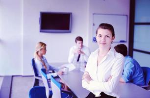 mulher de negócios com sua equipe em segundo plano no escritório foto