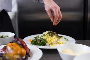 mãos de chef servindo risoto de legumes foto