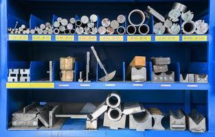 tubos, peças de metal e várias peças de metal para uma máquina cnc em uma prateleira foto