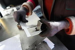 uma mulher que trabalha em uma moderna fábrica de produção e processamento de metais, preparando e medindo materiais que vão para o processamento de máquinas cnc foto