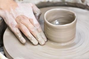 fazendo um copo de cerâmica na roda foto