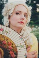 retrato de mulher loira vestida com roupas barrocas históricas com penteado à moda antiga, ao ar livre. foto