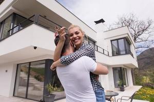 casal se abraçando em frente a nova casa de luxo foto