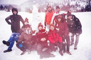 retrato de grupo de jovens posando com boneco de neve foto