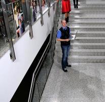 homem de negócios jovem em pé na escada e segure o laptop foto