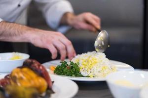 mãos de chef servindo risoto de legumes foto