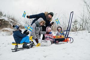 família escandinava com bandeira da suécia na paisagem sueca de inverno. foto