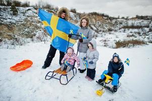 família escandinava com bandeira da suécia na paisagem sueca de inverno. foto