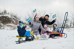 família escandinava com bandeira da suécia na paisagem sueca de inverno. foto