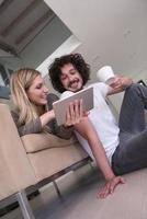 casal relaxando em casa com computadores tablet foto