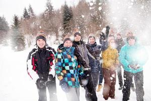 grupo de jovens jogando neve no ar foto