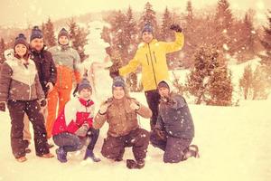 retrato de grupo de jovens posando com boneco de neve foto