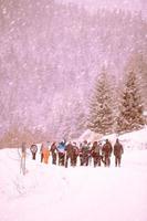 grupo de jovens caminhando pela bela paisagem de inverno foto