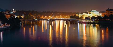 visão noturna panorâmica do rio vltava e ponte de manes foto