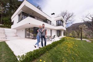 casal se abraçando em frente a nova casa de luxo foto