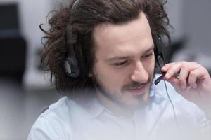 operador de call center masculino fazendo seu trabalho foto