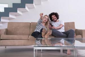 jovem casal no sofá assistindo televisão foto