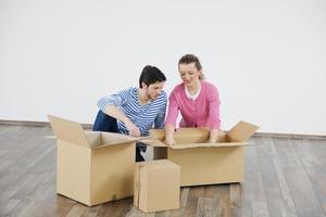 jovem casal se mudando para casa nova foto