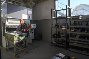 turquia, 2022 - mulher trabalhando em uma fábrica moderna e preparando material para uma máquina cnc. foto