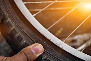 pneu da bicicleta estava furado e estacionado na calçada, o reparador está verificando. foco suave e seletivo no pneu. foto