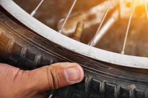 pneu da bicicleta estava furado e estacionado na calçada, o reparador está verificando. foco suave e seletivo no pneu. foto