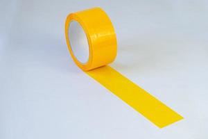 rolo de fita adesiva amarela em fundo isolado foto