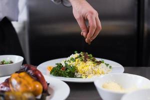 mãos de chef servindo risoto de legumes foto